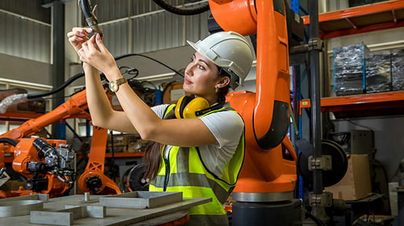 Woman fixing robot arm