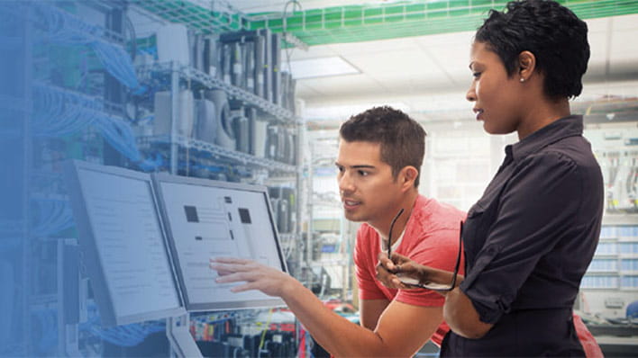 Two people looking at screen in workshop