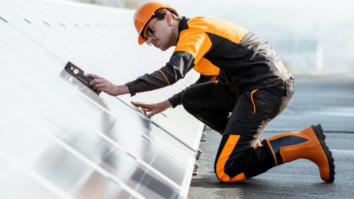 Person inspecting solar panel.