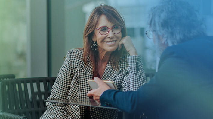 Two people having a conversation smiling