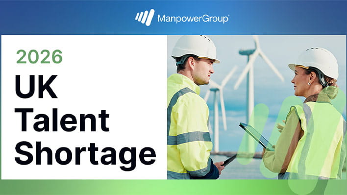 Two people wearing hard hats at a wind farm