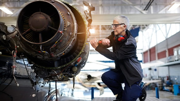 Woman working on jet engine