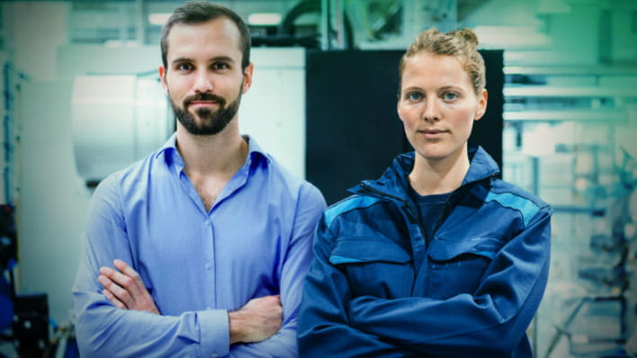 Man wearing blue shirt and woman wearing overalls.