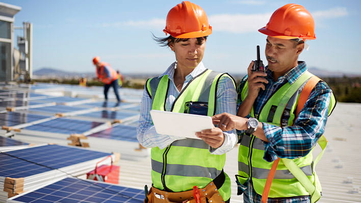 Two people in hardhats on a solar farm