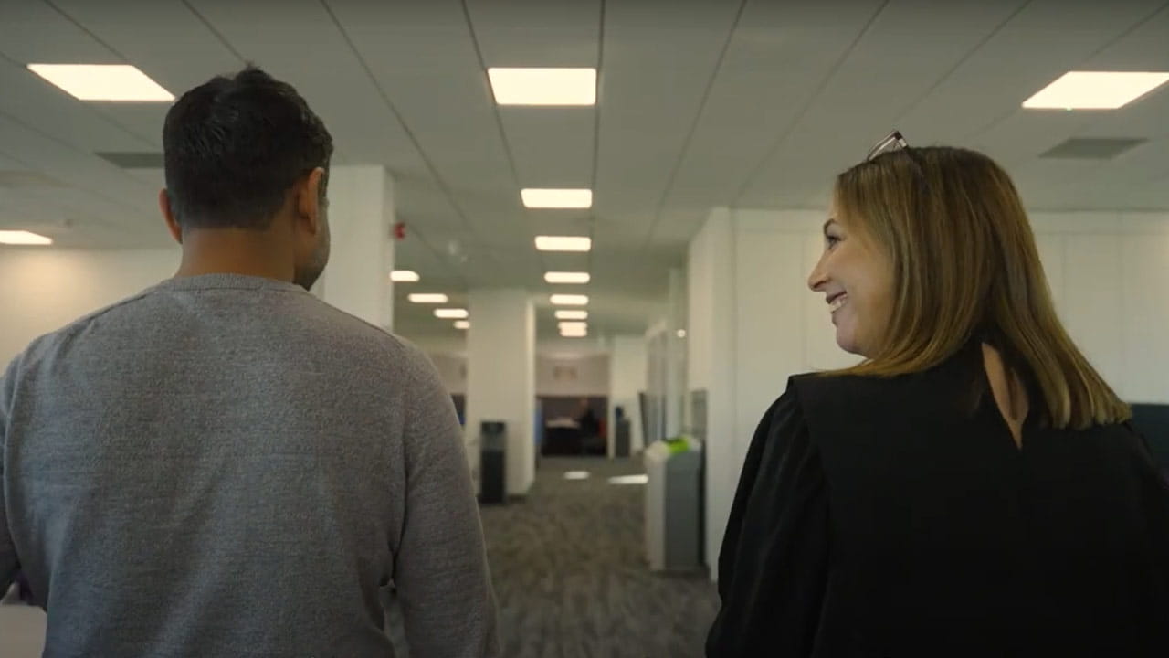 Two people walking in an office